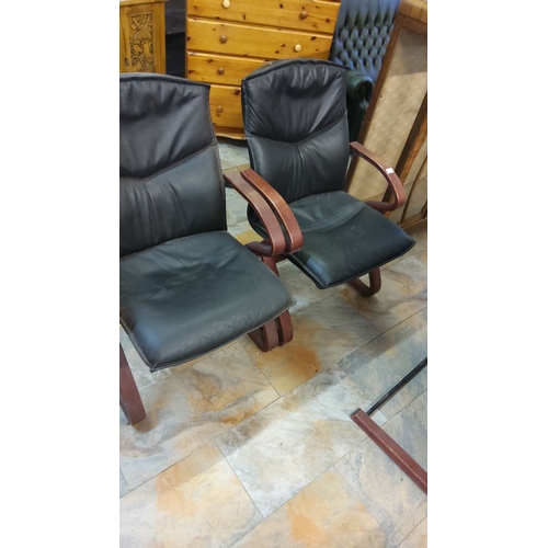 307 - Mid-century modern black leather chairs with curved wooden arms.