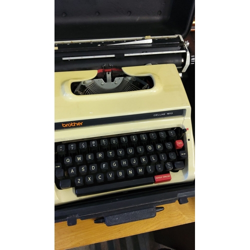 325 - Brother Deluxe 1613 typewriter in carrying case. Cream body with black keys and red accents. From th... 