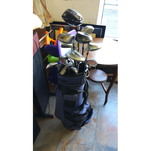 333 - Set of mixed golf clubs in a blue golf bag, featuring drivers and irons from various brands.