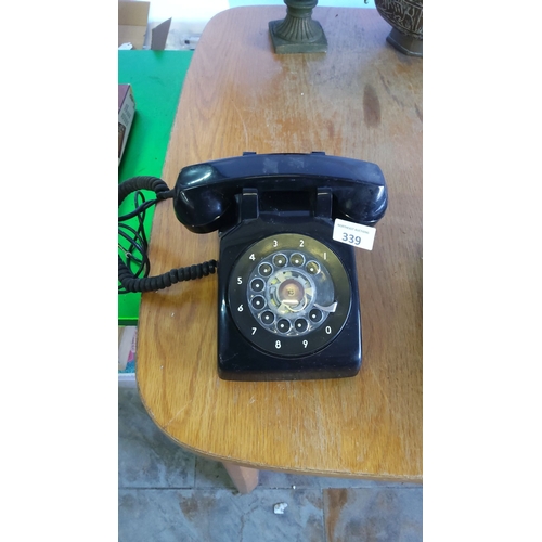 339 - Black rotary dial telephone, from the mid-20th century. Features original coiled cord and numerical ... 