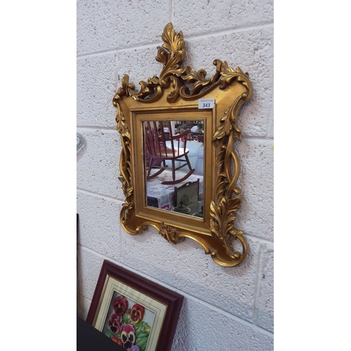 343 - Ornate gilded mirror with intricate rococo-style frame.