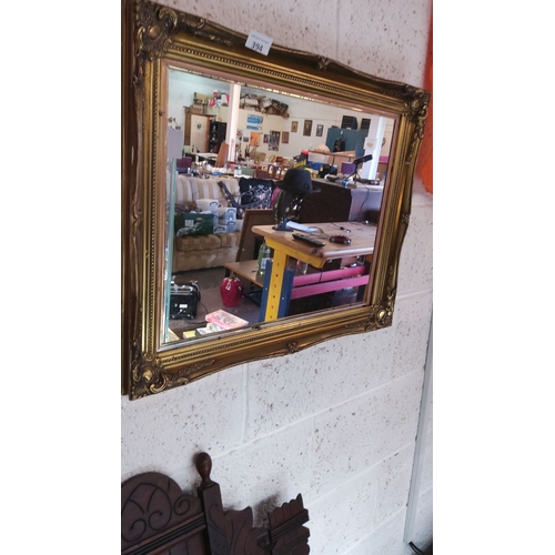 394 - Ornate vintage mirror with a gilded frame featuring intricate detailing.