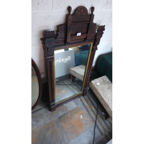 395 - Victorian-style wooden mirror with intricate cresting, featuring dark wood tones and decorative arch... 