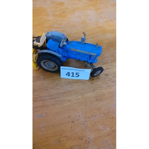 415 - Die-cast model of a Ford Super Major tractor with attached agricultural equipment. Features blue and... 