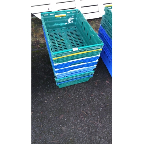 438 - Stack of multicolored plastic crates. Durable, stackable design.