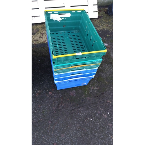 439 - Set of colorful plastic storage crates in green, blue, and yellow. Stackable design.