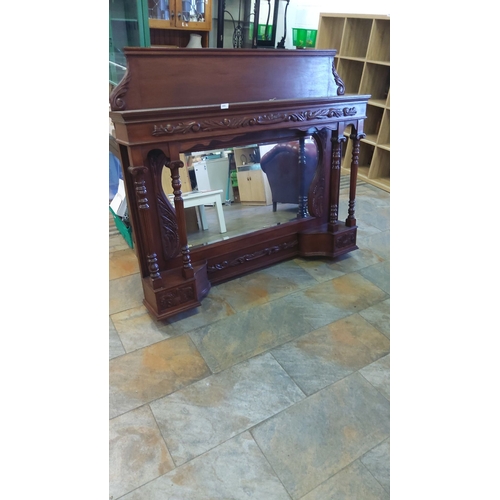 445 - Mahogany fireplace surround with ornately carved pillars and floral details, featuring a large bevel... 