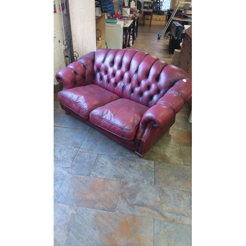 446 - Chesterfield-style red leather sofa features deep button tufting and rolled arms.