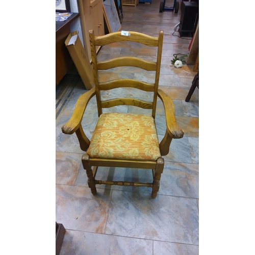 78 - Vintage oak ladder-back armchair with ornate upholstery, showcasing classic woodworking.