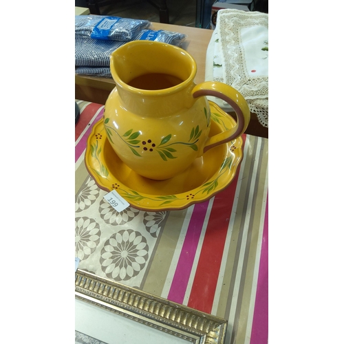 199 - Yellow ceramic pitcher and matching basin set, hand-painted with floral motifs.