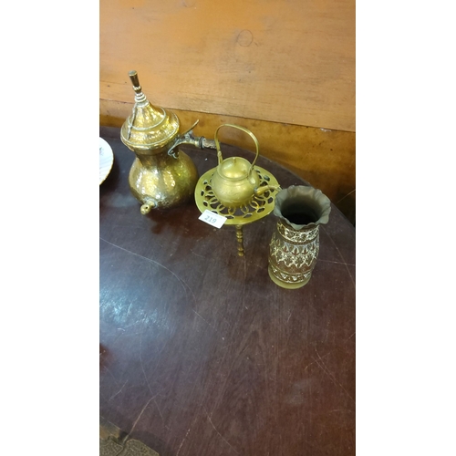 219 - Trio of brassware including a hammered coffee pot, small teapot with stand, and intricately etched v... 