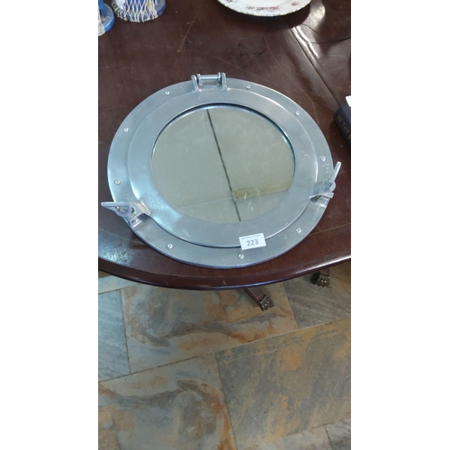 223 - Polished aluminum porthole mirror features functional latches and a circular design. Diameter: appro... 