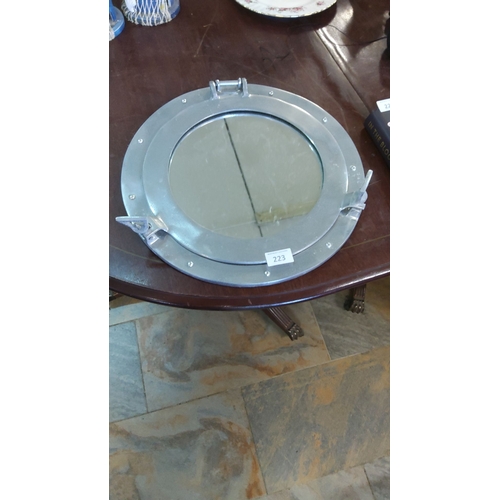 223 - Polished aluminum porthole mirror features functional latches and a circular design. Diameter: appro... 