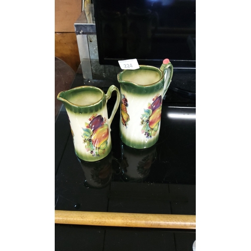 224 - Pair of English ceramic cream jugs, hand-painted fruit motifs, gradient green glaze, marked 