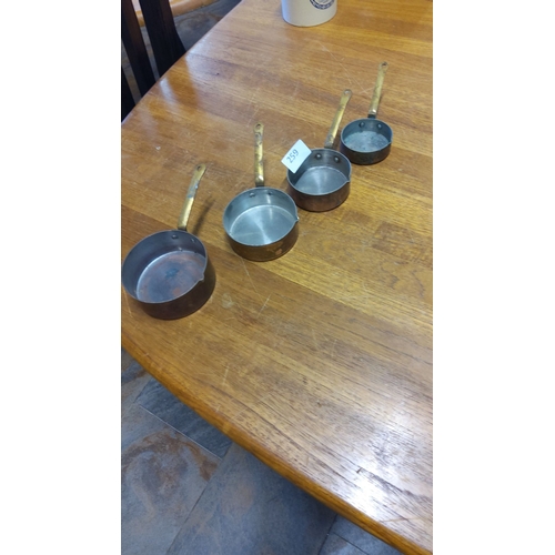 259 - Set of four vintage copper and brass miniature saucepans with riveted handles. Features a charming p... 