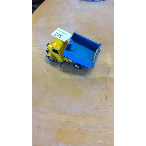 275 - Vintage Dinky Toys die-cast yellow and blue tipper truck, with an aged patina. From the mid-20th cen... 