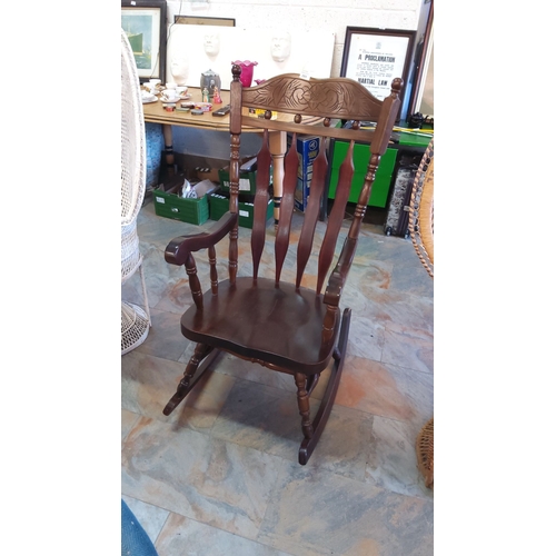 289 - Vintage carved wooden rocking chair, featuring a floral motif on the backrest with a polished finish... 