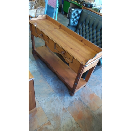 293 - Vintage pine console table with raised back rail, three drawers, lower shelf, and turned supports.