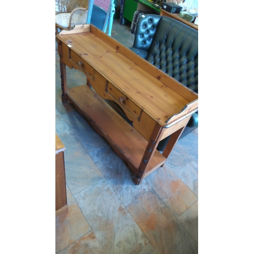 293 - Vintage pine console table with raised back rail, three drawers, lower shelf, and turned supports.