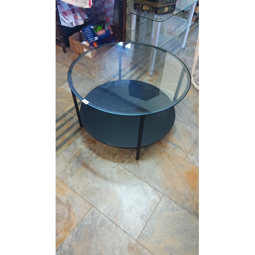 294 - Modern two-tier circular coffee table features a sleek metal frame with a tempered glass top and she... 