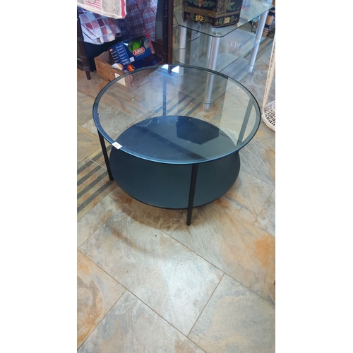 294 - Modern two-tier circular coffee table features a sleek metal frame with a tempered glass top and she... 