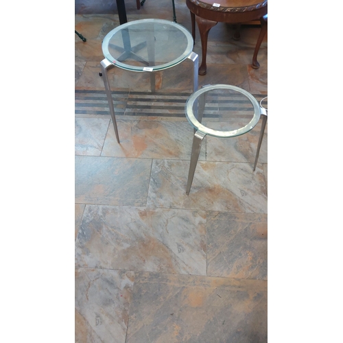 304 - Set of two modern nesting tables with sleek brushed metal frames and glass tops.