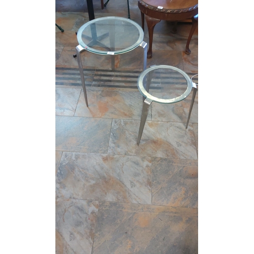 304 - Set of two modern nesting tables with sleek brushed metal frames and glass tops.