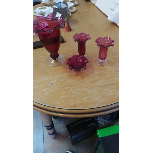 334 - Set of four cranberry glass ruffled-edge vases and bowl with clear bases.