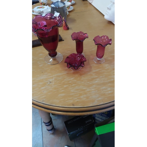 334 - Set of four cranberry glass ruffled-edge vases and bowl with clear bases.