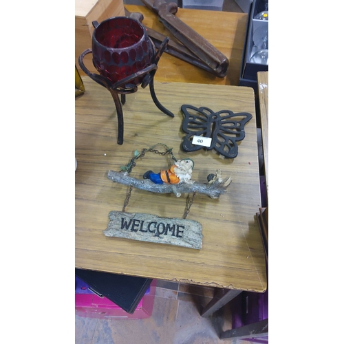 40 - Mixed lot includes a red glass votive on a wrought iron base, a cast iron butterfly trivet, and a we... 