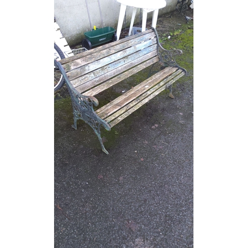 467 - Vintage cast iron and wood garden bench, featuring ornate side panels and weathered slatted seat.