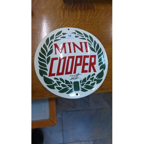 54 - Mini Cooper enamel sign features an iconic red and green design with a laurel wreath. The sign is pr... 