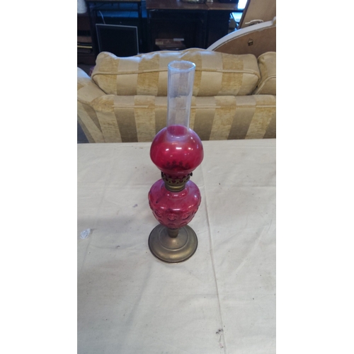 3 - Victorian-style cranberry glass oil lamp with ornate embossed design, brass base, and clear glass ch... 