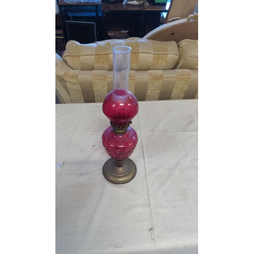 3 - Victorian-style cranberry glass oil lamp with ornate embossed design, brass base, and clear glass ch... 