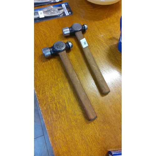 56 - Pair of vintage ball-peen hammers featuring wooden handles and steel heads.