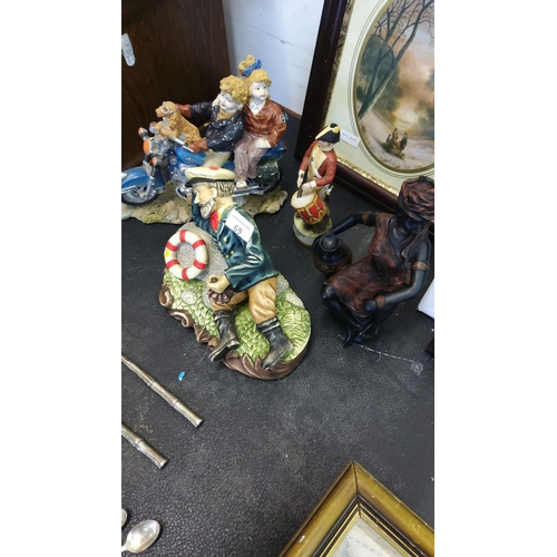 69 - Assorted decorative figurines include a maritime-themed sailor, motorbike couple, and drummer boy. T... 