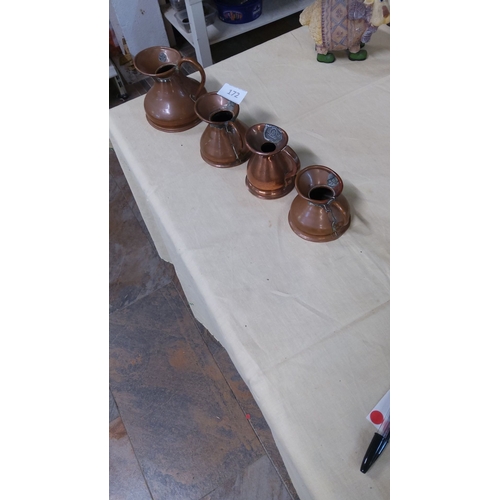 172 - Set of four antique copper measuring jugs with official verification stamps.