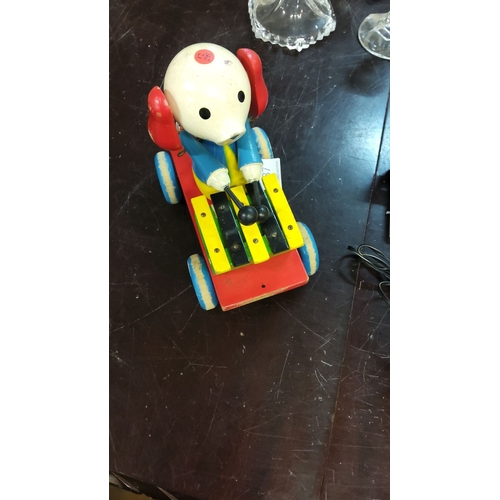 187 - Vintage wooden pull-toy features a xylophone-playing dog on wheels. It is hand-painted in bright pri... 