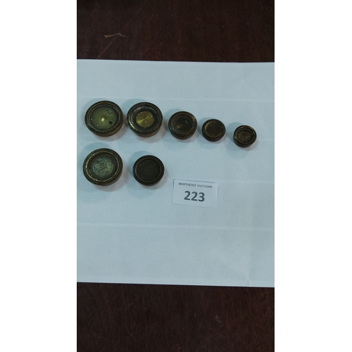 223 - Set of seven antique brass shop weights from the 19th century. Various sizes with engraved markings.