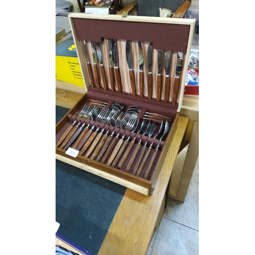 233 - Vintage part cutlery set with stainless steel blades and wooden handles, presented in a fitted woode... 