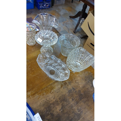 248 - Assortment of cut glass bowls and vases, featuring intricate patterns and scalloped edges.