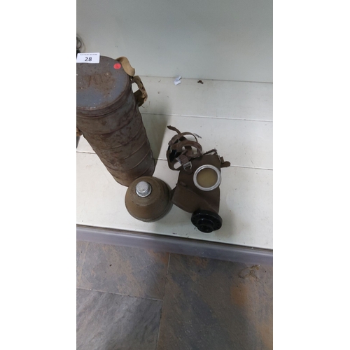 28 - WWII-era military gas mask with original metal storage canister and filter, aged patina, canvas stra... 