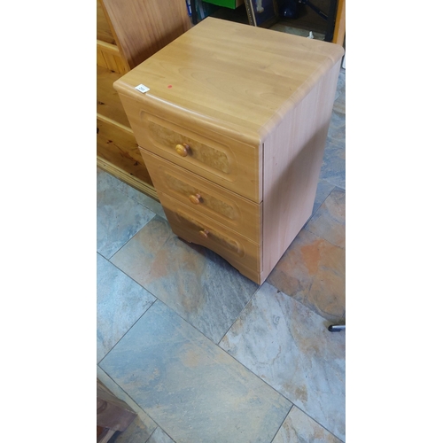 293 - Solid Light wood three-drawer bedside cabinet with decorative veneer panels and round wooden handles... 