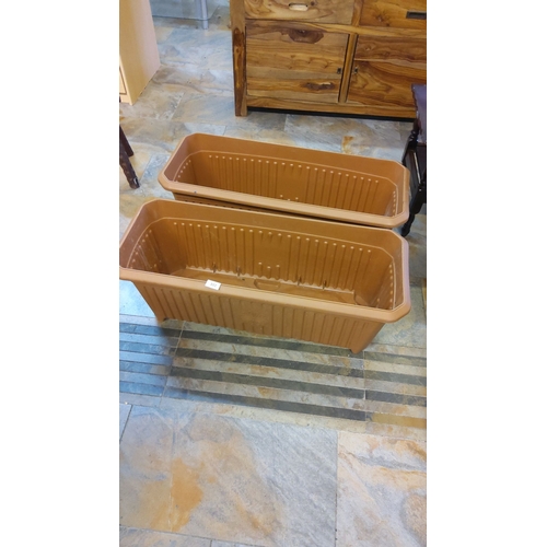 302 - Pair of large rectangular plastic planters in a terracotta hue. They feature a practical drainage de... 