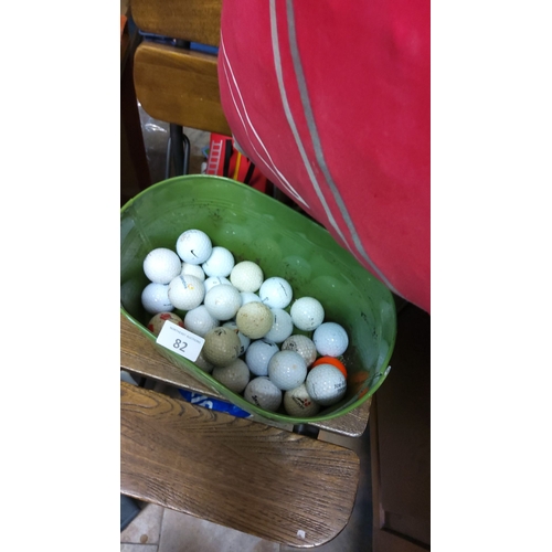 82 - Large lot of assorted used golf balls in a green plastic bucket. Various brands and conditions.(25+)