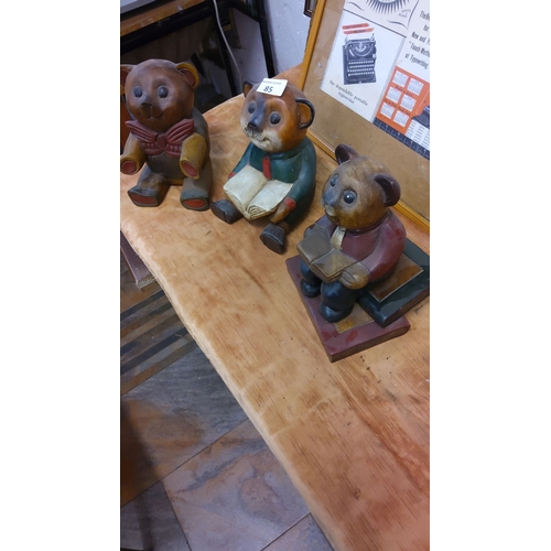 85 - Trio of hand-painted wooden bear figurines, each depicted reading. Intricately carved with vintage a... 