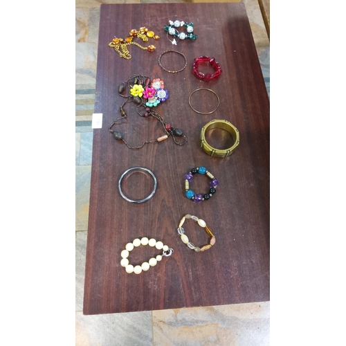 246 - Vintage costume jewelry lot, including beaded necklaces, bangles, and stretch bracelets in mixed mat... 