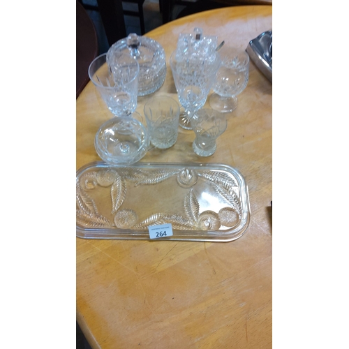 264 - Cut glass lot featuring stemware, covered dishes, and an etched serving tray with intricate patterns... 