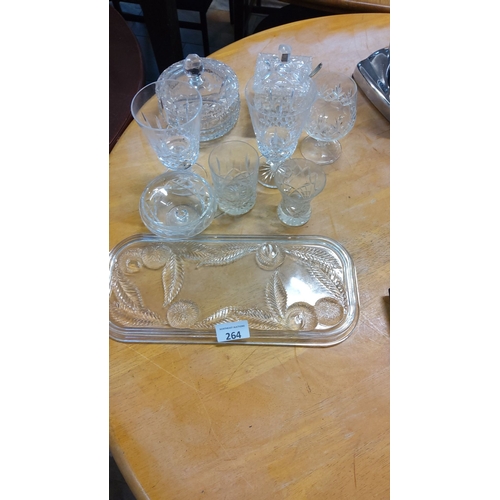 264 - Cut glass lot featuring stemware, covered dishes, and an etched serving tray with intricate patterns... 