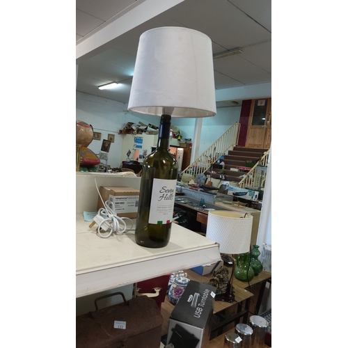 121 - Upcycled wine bottle table lamp with fabric shade and wired power cord.